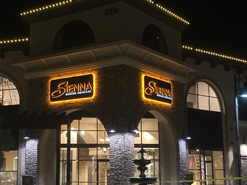 Sienna Modern American illuminated exterior signage photographed at night, fabricated and installed by Pacific West Signs.